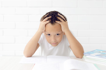 schoolboy teaches lessons, studying books writing in a notebook on a white background