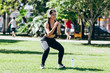 © kleberpicui - Young muscular fitness woman doing squats exercise in the park