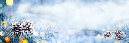 Fotografie, Obraz Christmas Decoration Banner - Snowy Pine Cones On Spruce Branch With Lights