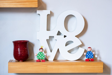 Wall Mural - There is a couple of dolls on the shelter made by wood. They are smiling and looks very happy. The male doll is holding a hourglass on left hand.