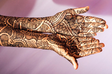 Woman Hands with black mehndi tattoo. Hands of Indian bride girl with black henna tattoos. Fashion. India