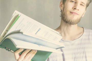 handsome young bearded man carry small pile of books in university f