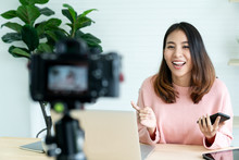 Young Attractive Asian Woman Blogger Or Vlogger Looking At Camera And Talking On Video Shooting With Technology. Social Media Influencer People Or Content Maker Concept In Relax Casual Style At Home.