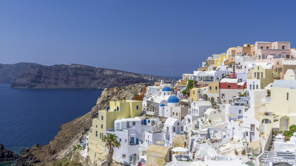 Wall Mural - Blocks of the city of Oia on the rocks near the sea