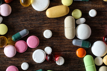 Wall Mural - Medications on a textured wooden background