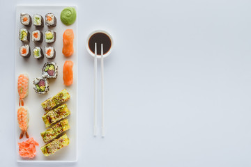 Wall Mural - delicious sushi set and soy sauce in bowl with chopsticks isolated on white background