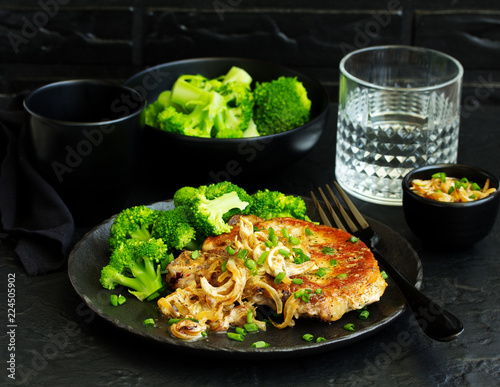Fotografie, Obraz Fried pork steak with broccoli and onion sauce.