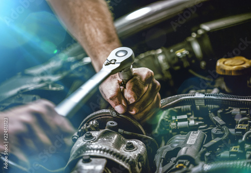 Obraz Dibond Auto mechanik pracuje na silniku samochodowym w garażu mechanika. Serwis naprawczy. autentyczne zbliżenie