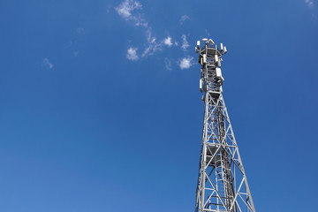 Telecommunication tower with antennas with blue sky .