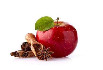 Red apple with leaf, cinnamon and anise on white background