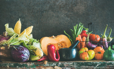 Wall Mural - Fall vegetarian food ingredients. Assortment of various Autumn vegetables for healthy cooking over rustic cupboard, dark wall background, copy space, selective focus. Local market organic produce