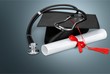 © BillionPhotos.com - Graduation hat with tassel, diploma with red