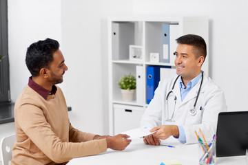 Poster - medicine, healthcare and people concept - doctor giving prescription to male patient at clinic