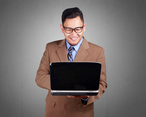 Wall Mural - Young Businessman Looking at Laptop, Smiling Expression