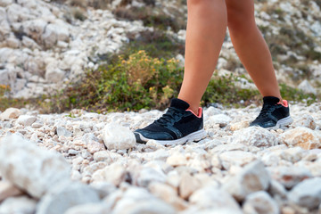 Wall Mural - legs of hiker woman on trekking trail in mountain, travel and active lifestyle concept