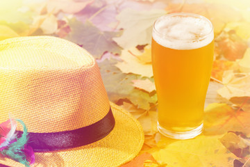 Wall Mural - Beer glass pint octoberfest picnic on natural background with hat and autumn leaves