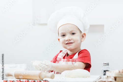 Fotografie, Obraz Boy with chef hat preparing the pizza dough
