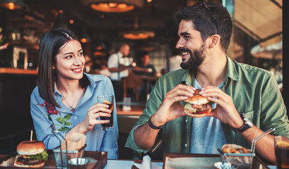 Beautiful young couple sitting in a cafe, having breakfast. Love, dating, food, lifestyle concept