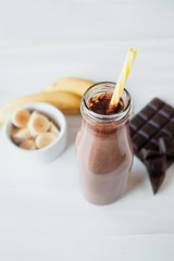 Wall Mural - Banana and chocolate smoothie in the glass jar milkshakes, natural and organic drink