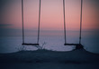 swing at sunset on the shore of the frozen winter sea