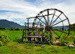 Large wooden turbine baler (water wheel) place on rice field and small canal at Thai-Dam Cultural Village in Chiang Khan, Loei Province, Thailand