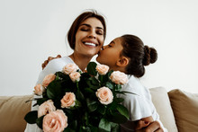 Family. Love. Holiday. Mom And Daughter. Girl Is Giving A Bouquet For Her Mother And Kissing Her, Woman Is Smiling; At Home