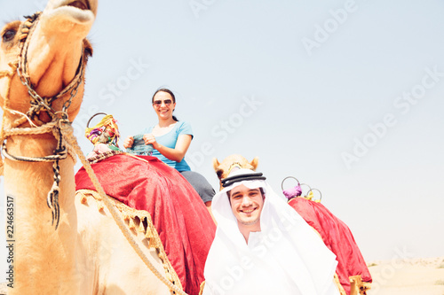Fotografia, Obraz Arabian Man And Tourist Riding A Camel