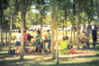 Abstract blurred group of friend and family members enjoy barbecue on lakeside picnic area. Outdoor camping and folding chairs at park in Grand Prairie, Texas, US. Outside Party and BBQ Concept