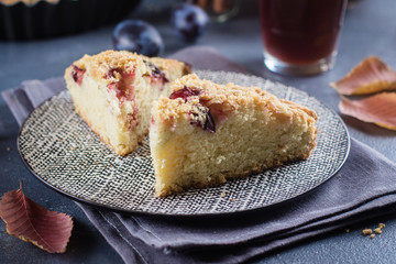 Wall Mural - Homemade rustic plum cake on dark concrete background. Sweet fruits pie.