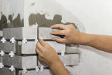 Fototapeta  - Laying Ceramic Tiles. The Builder makes repairs.