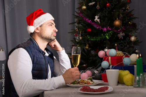 Fotografia Sad male in hat celebrate the New Year with champagne