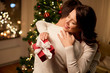 © Syda Productions - winter holidays and people concept - happy couple with christmas gift hugging at home
