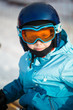 Girl in a helmet and ski glasses in the mountains