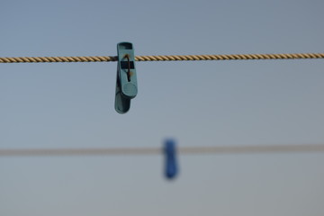 colorful clothespin hanging on a rope with blue sky in background