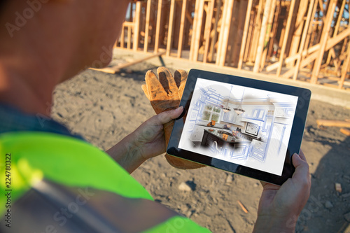 Fotografie, Obraz Female Construction Worker Reviewing Kitchen Illustration on Computer Pad at Con