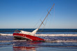 A red yacht run aground on a New Brighton beach 