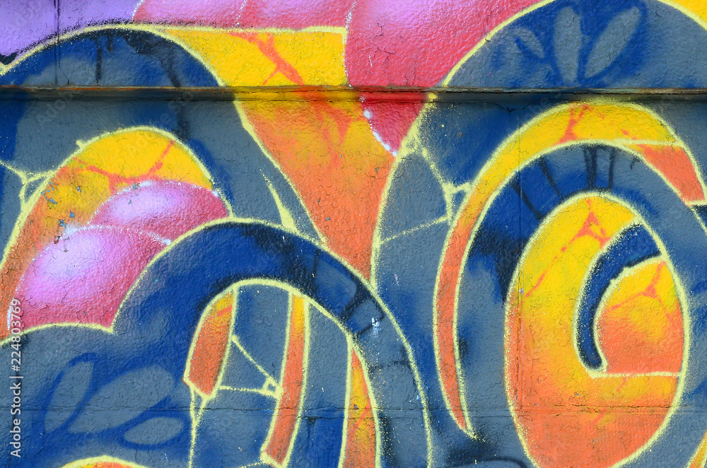 Fragment of graffiti drawings. The old wall decorated with paint stains in the style of street art culture. Colored background texture in warm tones - obrazy, fototapety, plakaty 