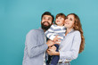 © master1305 - A happy family on blue studio background. The father, mother and son posing together