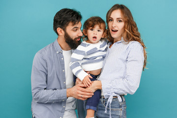 Wall Mural - A happy family on blue studio background. The father, mother and son posing together