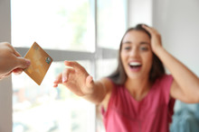 Happy Young Woman Stretching Hand For Credit Card