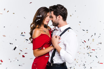 heart to heart. young beautiful couple dancing while standing against white background with confetti