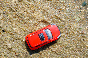 Wall Mural - bright red car on the sand, toy car on a summer day