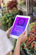 © LIGHTFIELD STUDIOS - cropped image of florist holding tablet with shopping appliance near flower shop
