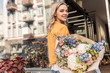 © LIGHTFIELD STUDIOS - attractive girl holding beautiful bouquet near flower shop