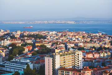 Wall Mural - Beautiful super wide-angle aerial view of Lisbon, Portugal with harbor, skyline, scenery beyond the city and 25 de Abril Bridge, over the Tagus river, shot from belvedere observation deck