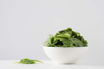 Wall Mural - raw spinach leaves in a white bowl