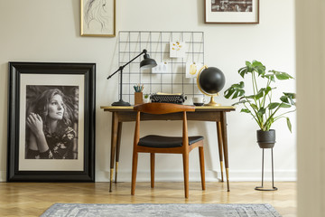 Canvas Print - Wooden chair at desk with lamp in white freelancer's interior with plant and posters. Real photo