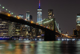 Fototapeta  - Long time exposure of New York City Manhattan downtown skyline and Brooklyn Bridge  at night viewed from Brooklyn Bridge park