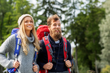 travel, tourism, hiking and people concept - couple of travelers with backpacks outdoors