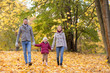 © Syda Productions - family, season and people concept - happy mother, father and little daughter walking at autumn park